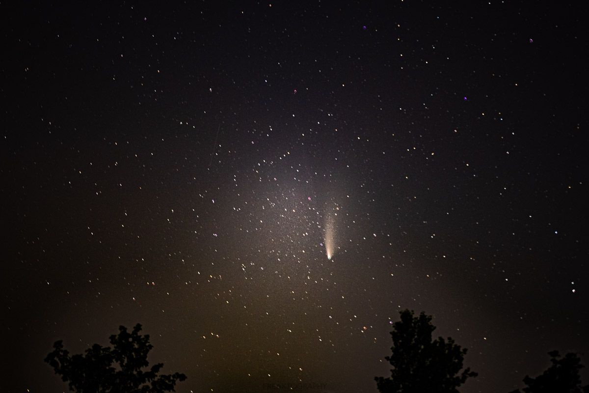 A comet is flying through a starry night sky.
