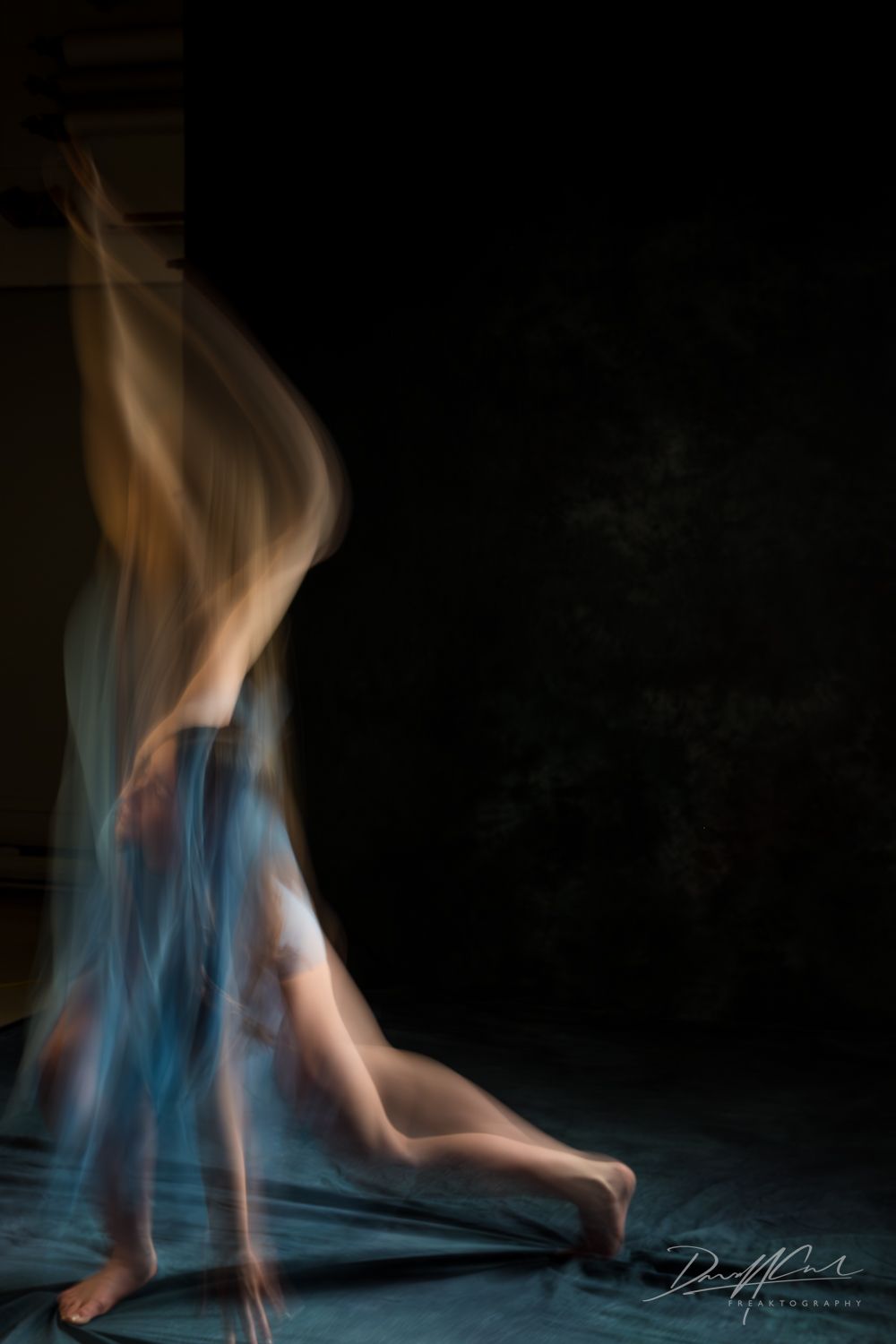 Ballerina in blue captured with motion blur using a slow shutter, showing abstract movement and dance