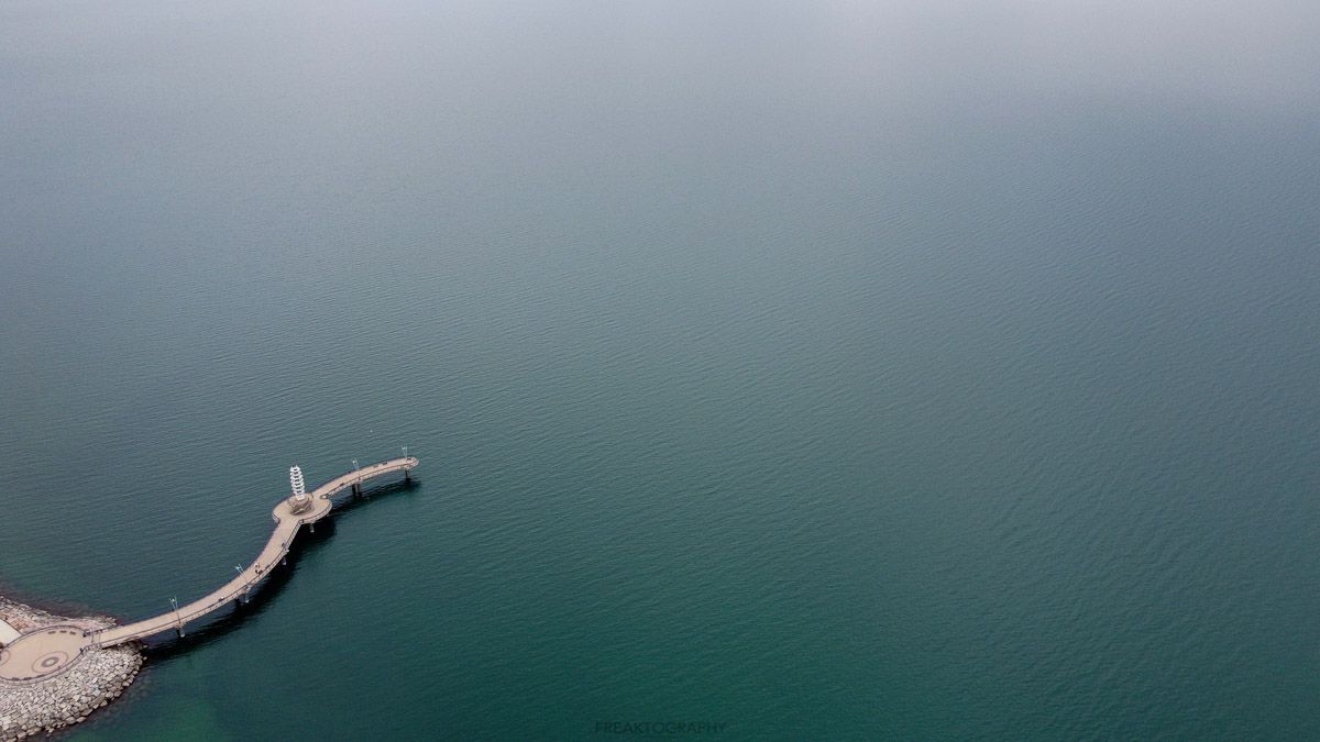 An aerial view of a pier in the middle of a large body of water.
