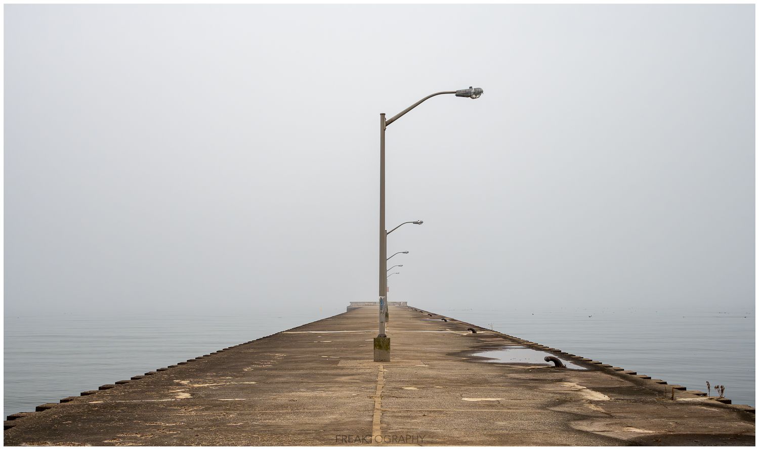 A pier with a street light at the end of it