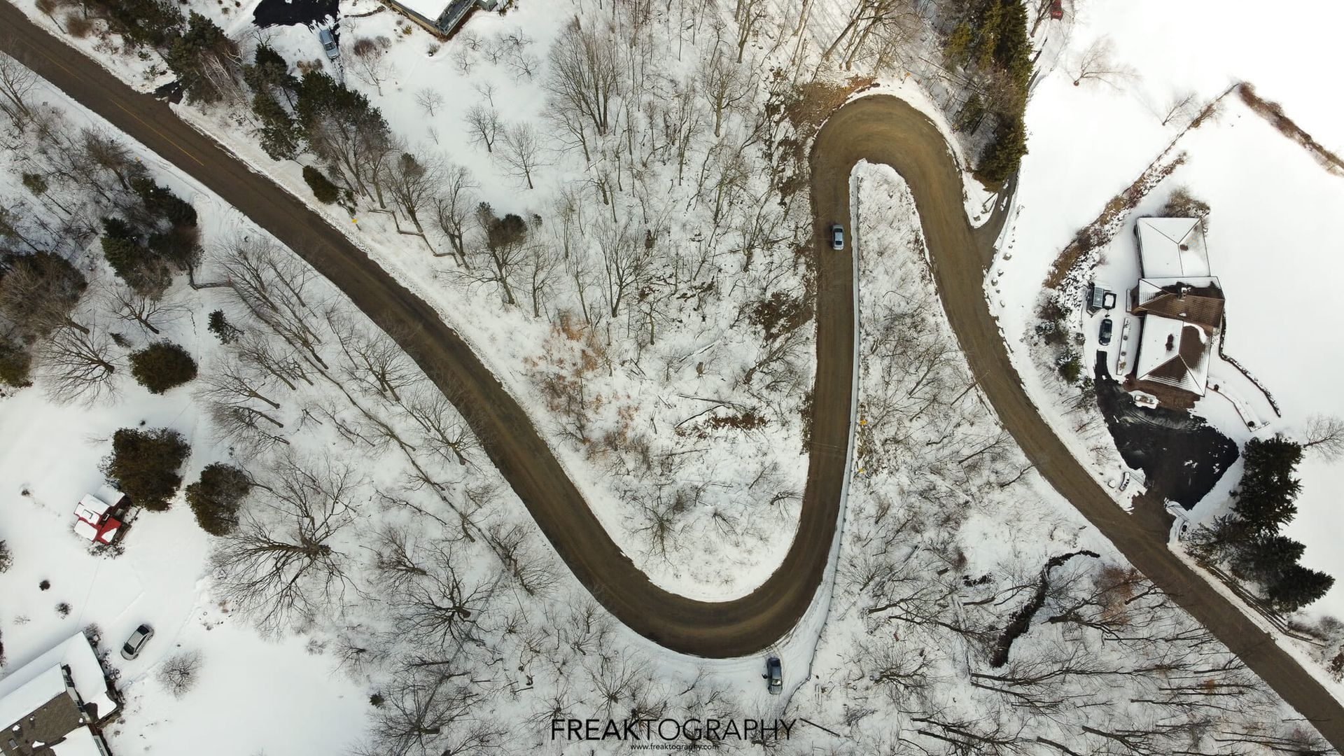 An aerial view of a winding road in the snow