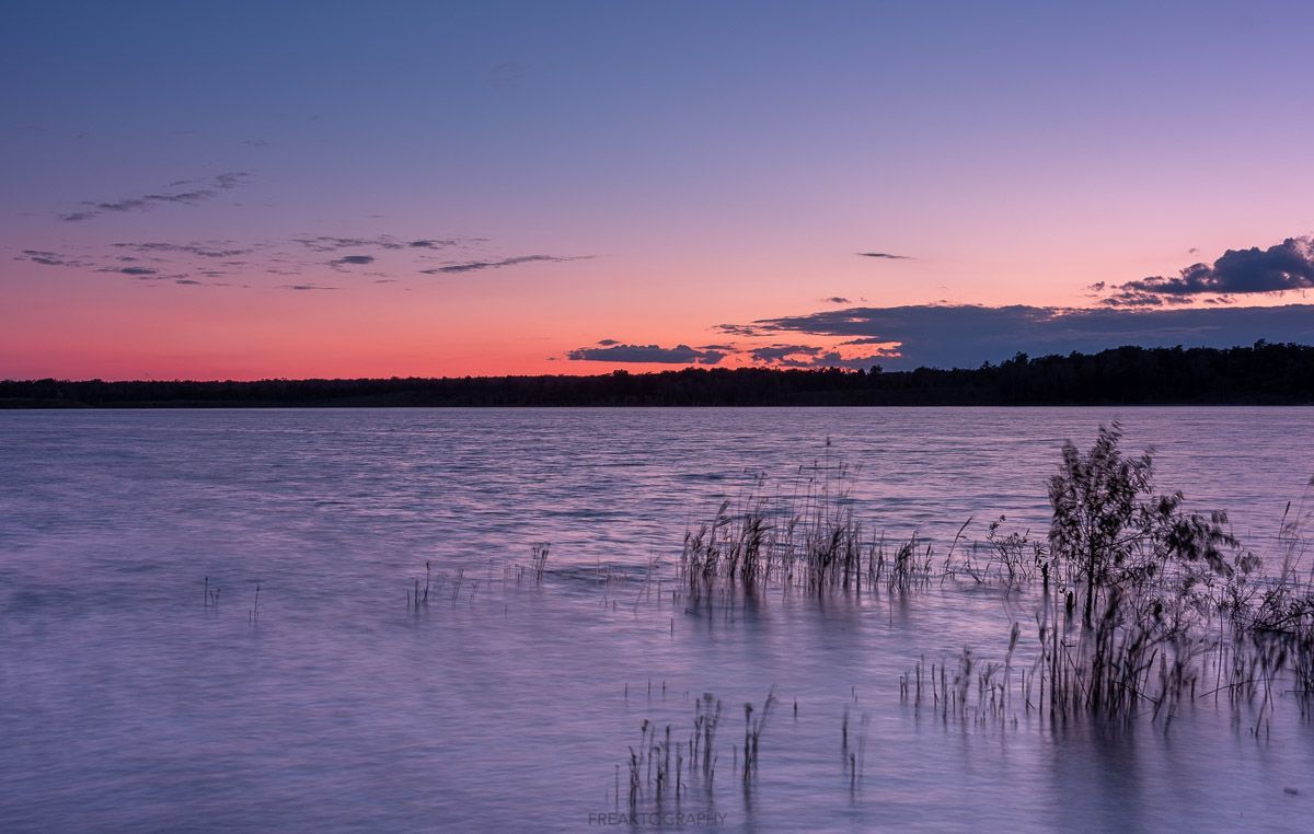 A large body of water with a sunset in the background.