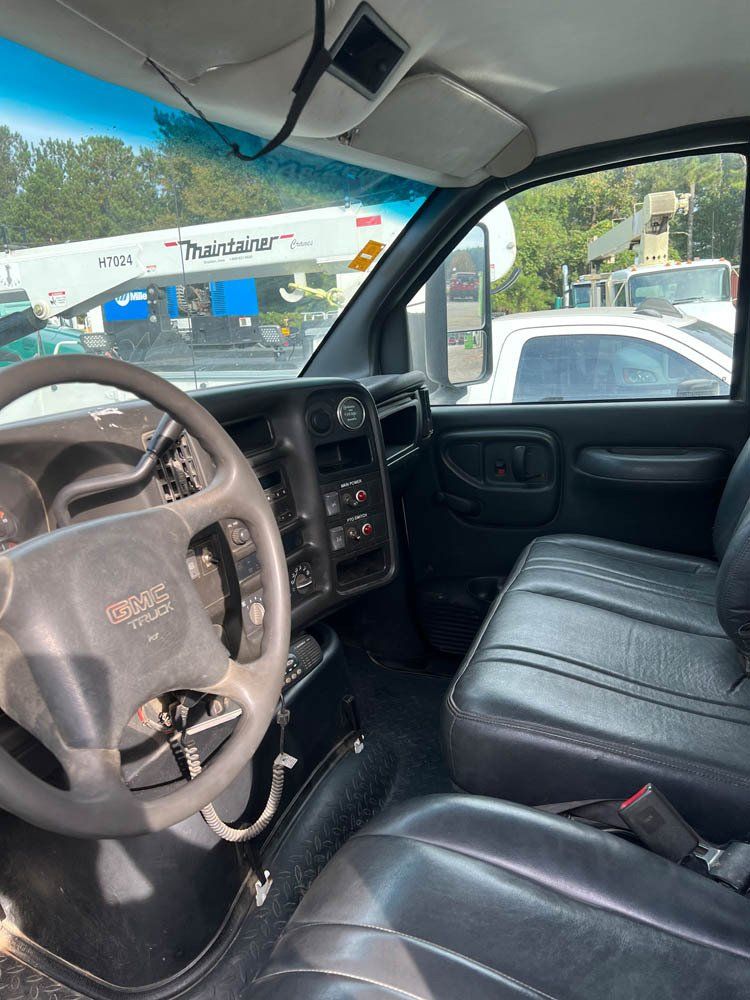 The inside of a truck with a steering wheel and seats.