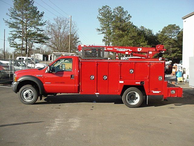 A red utility truck is parked in a parking lot