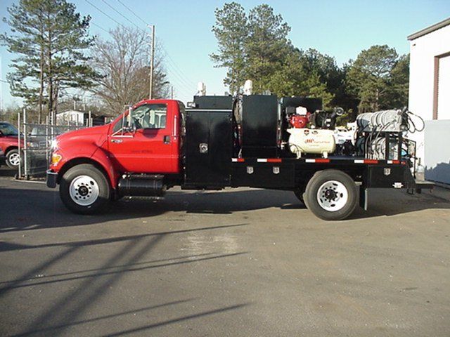 A red and black truck is parked in a parking lot