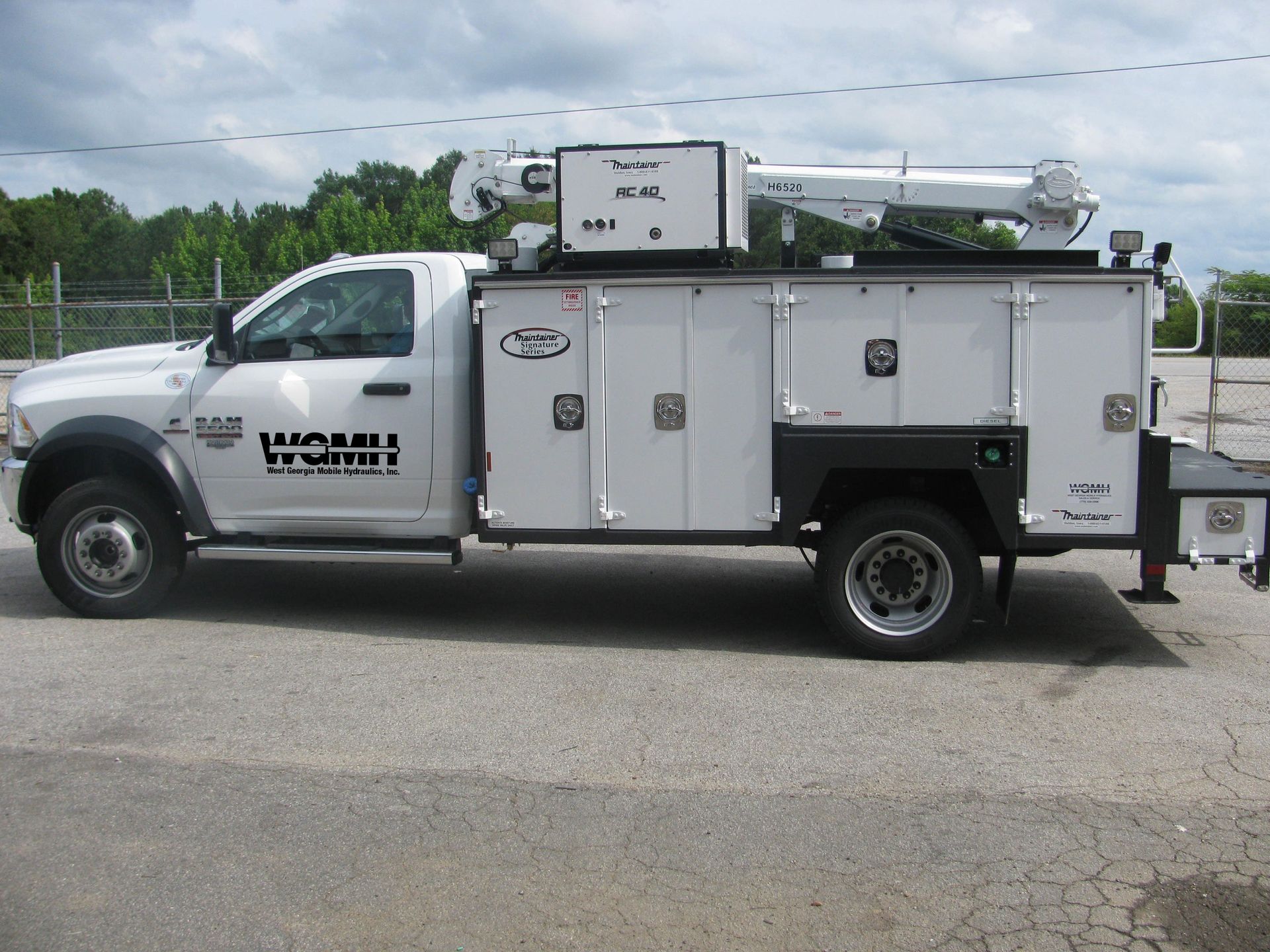 A white utility truck is parked in a parking lot