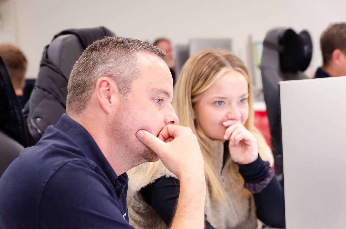 A group of people are looking at a laptop computer.