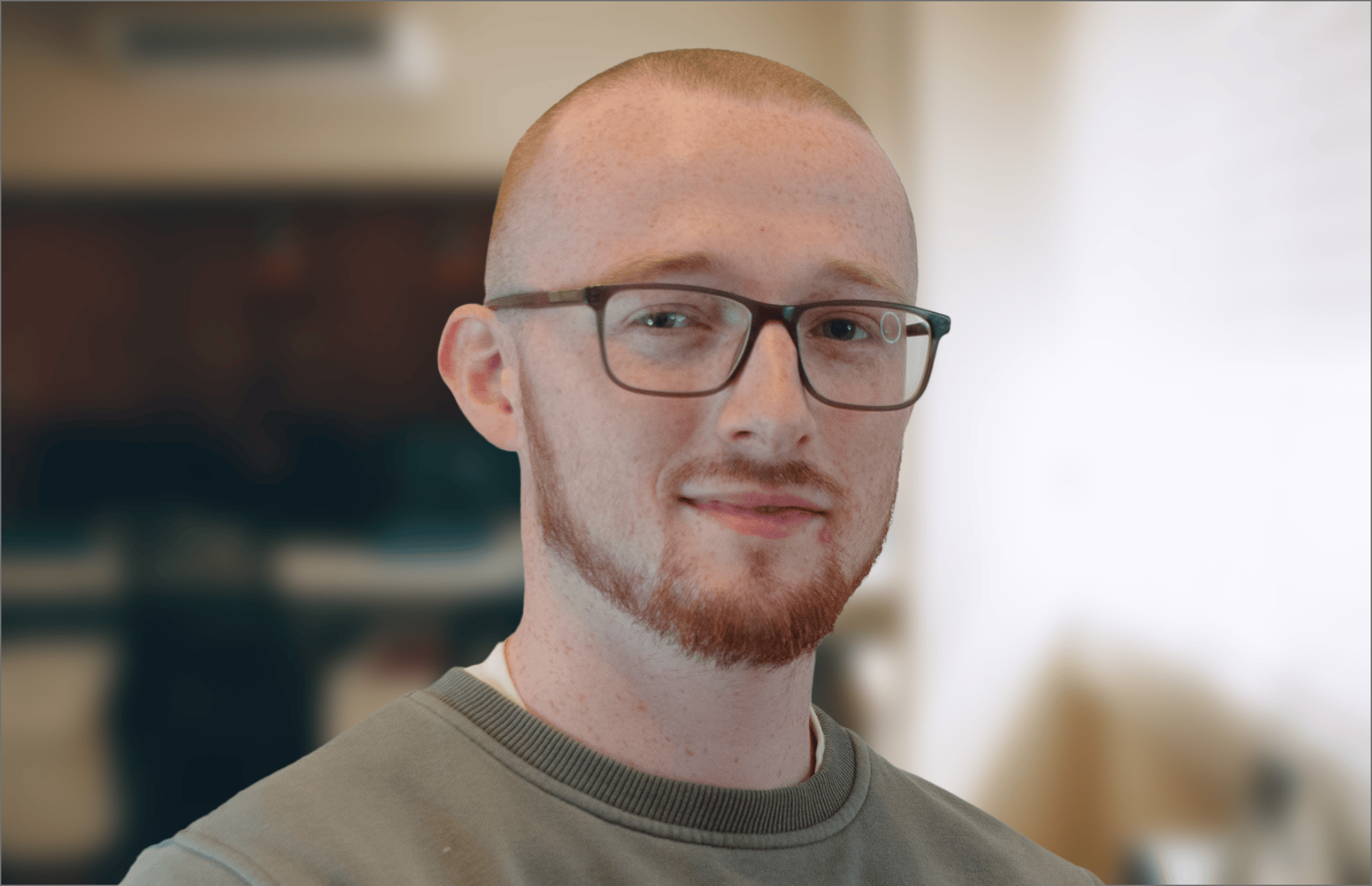 A man with glasses and a beard is smiling for the camera.