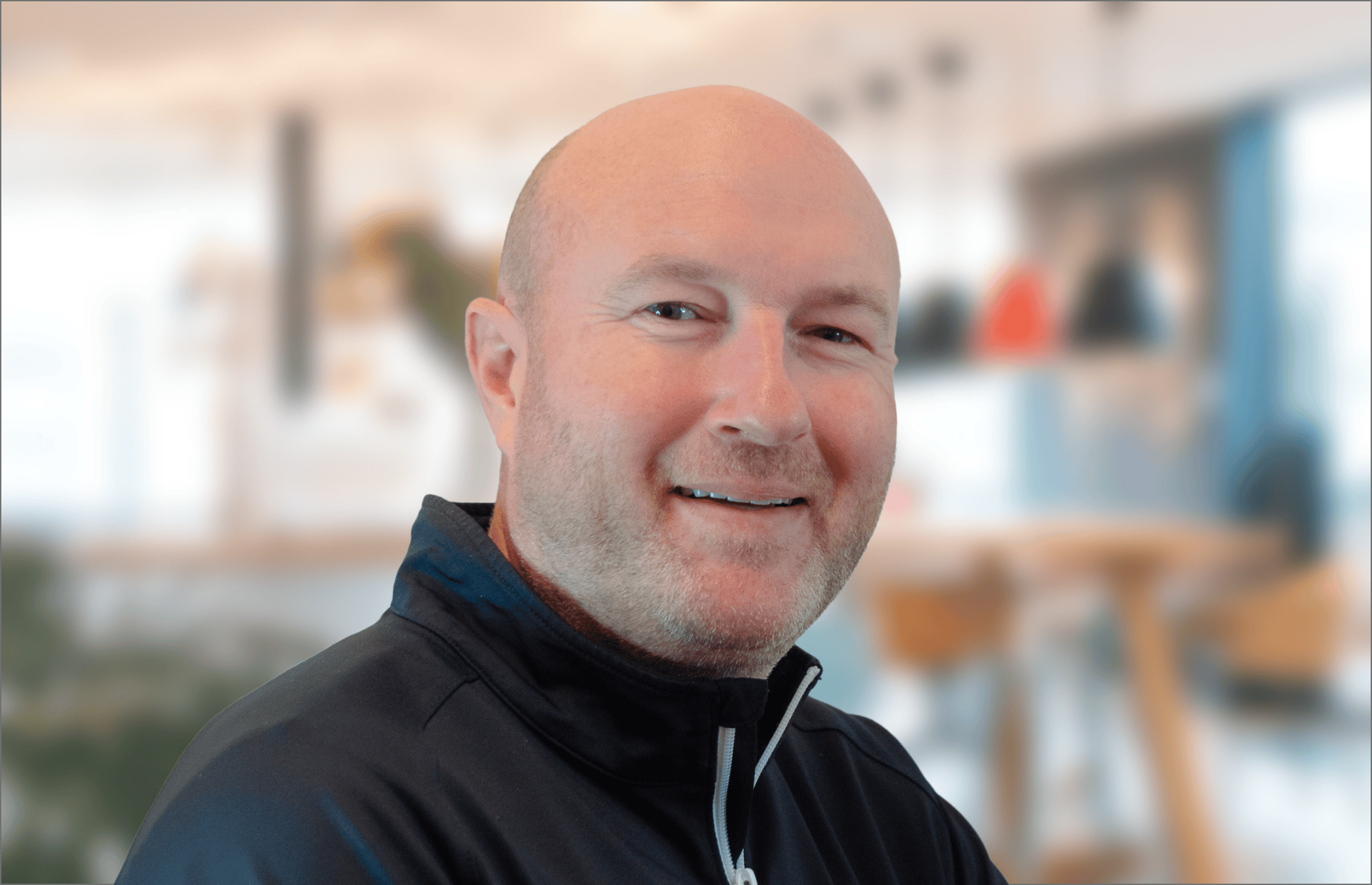 A bald man with a beard is smiling for the camera.