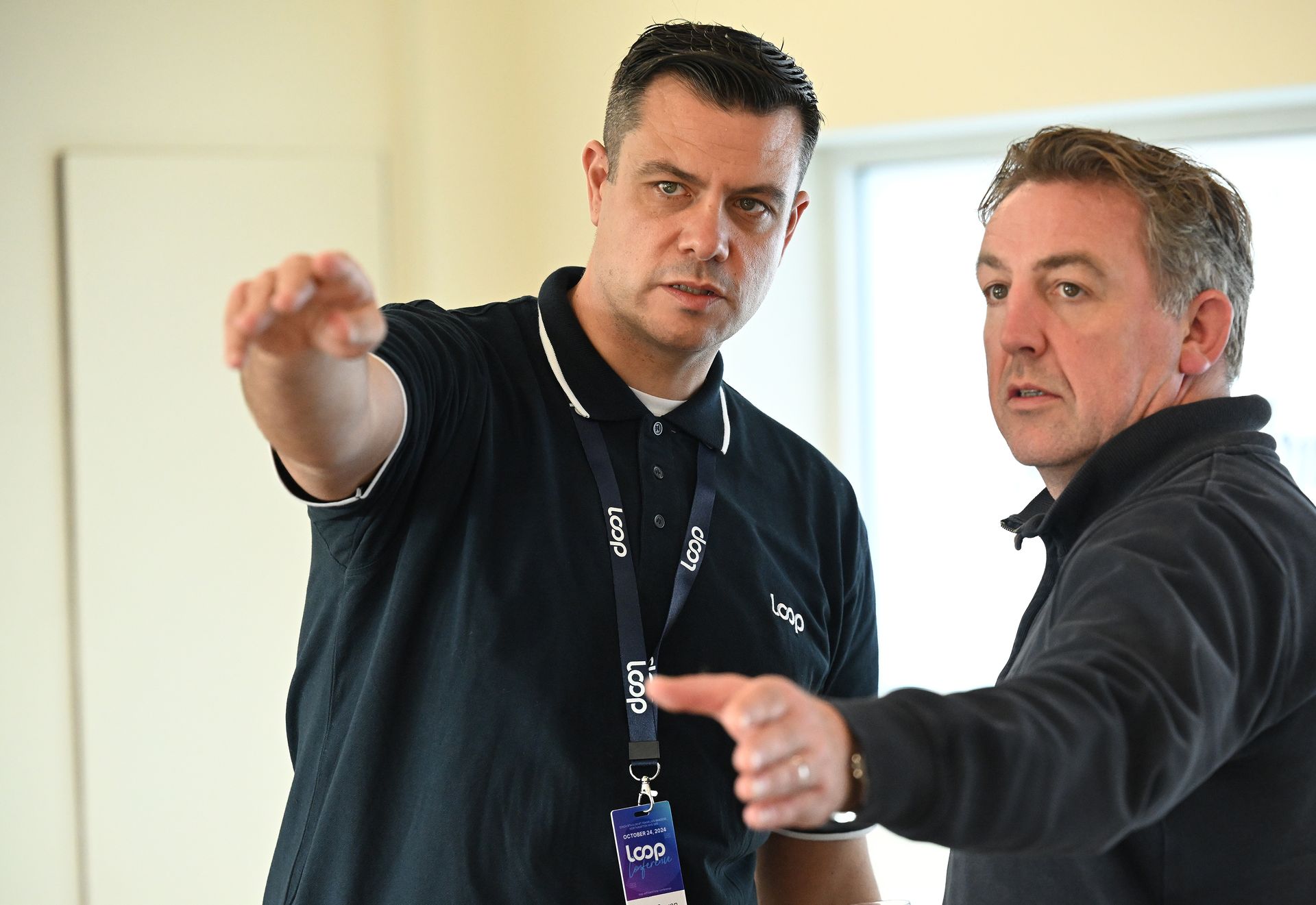 A computer monitor is sitting on a wooden desk in an office.