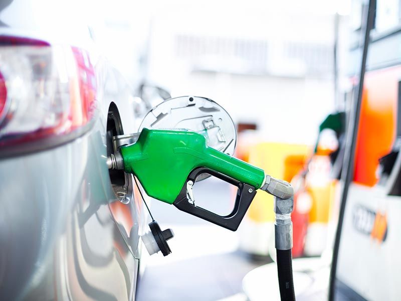 Green fuel nozzle refueling a vehicle at a diesel fuel station, highlighting efficient diesel fuel s