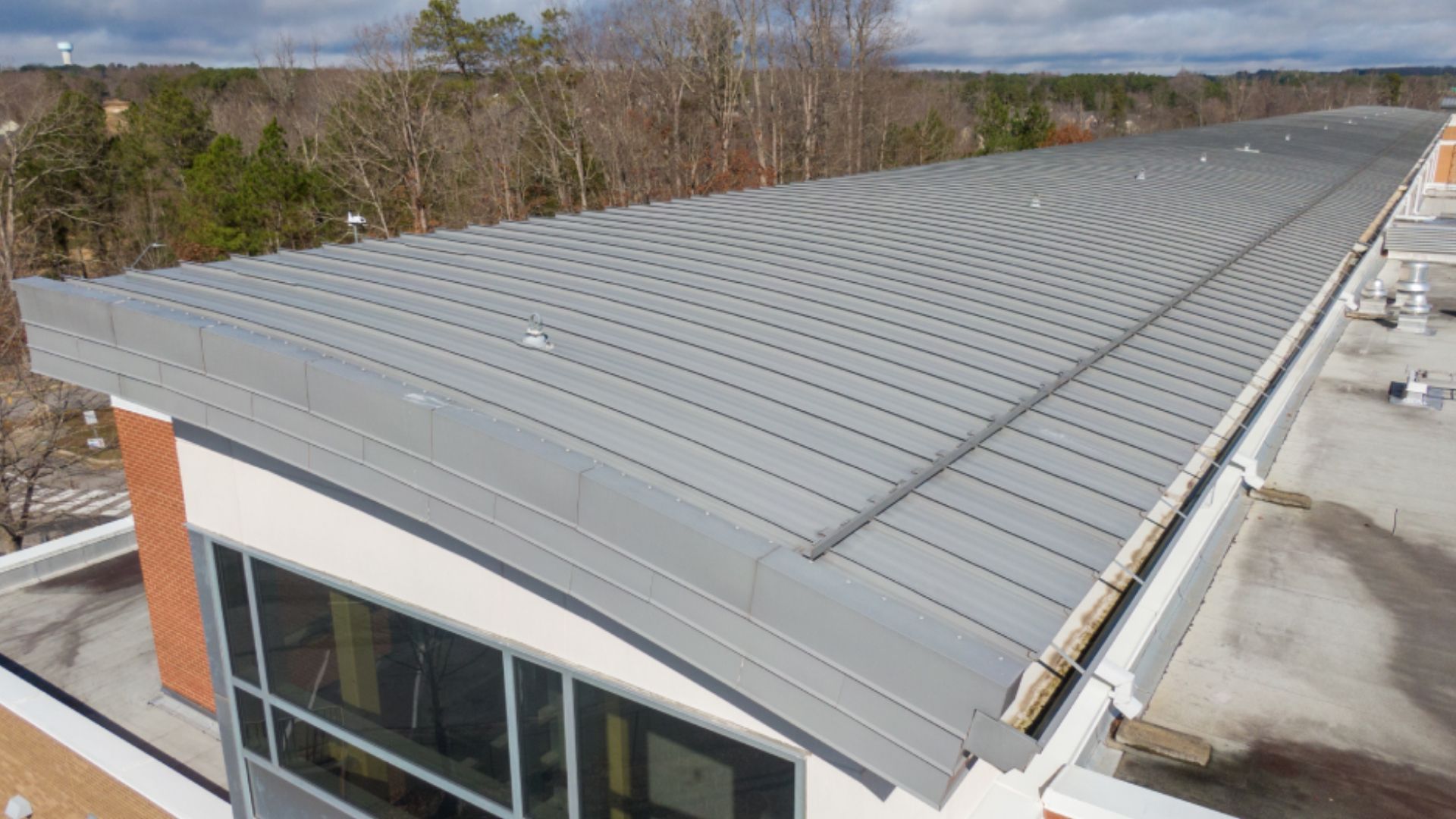 An aerial view of a roof of a building with trees in the background.