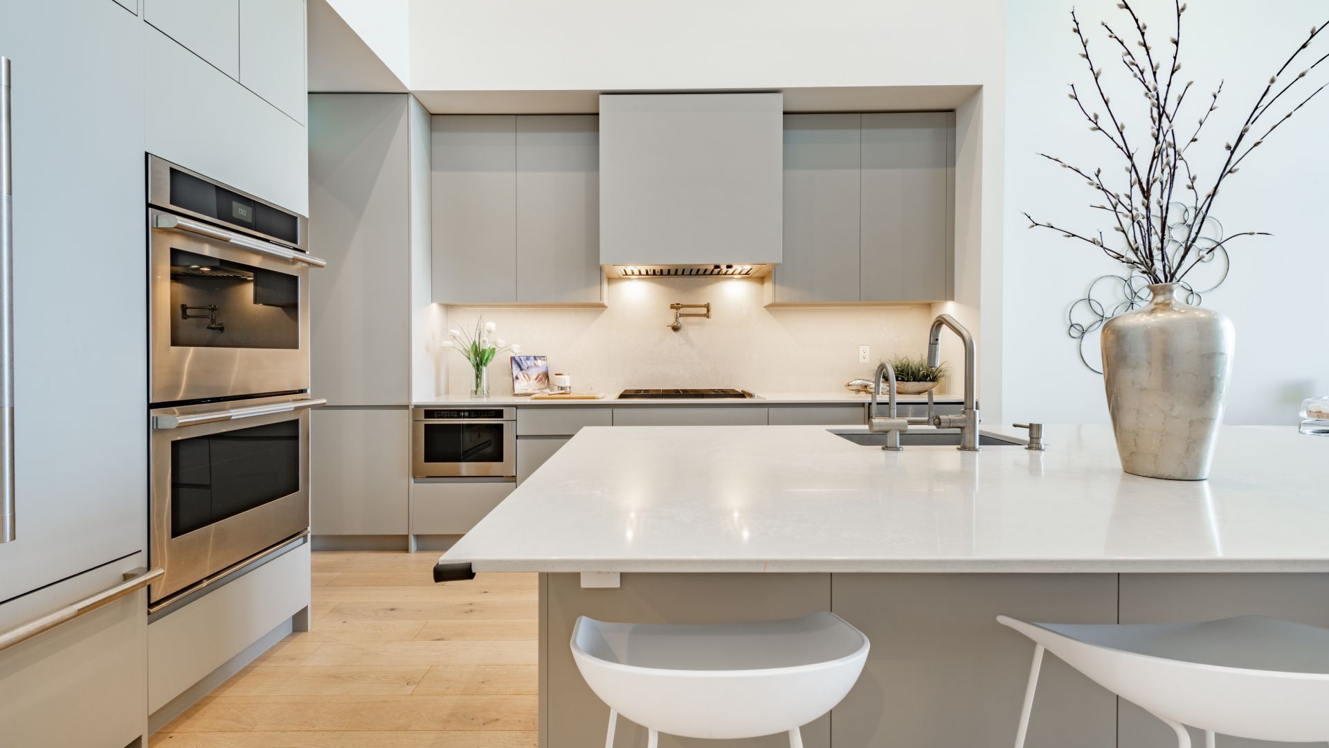 A kitchen with stainless steel appliances and white counter tops