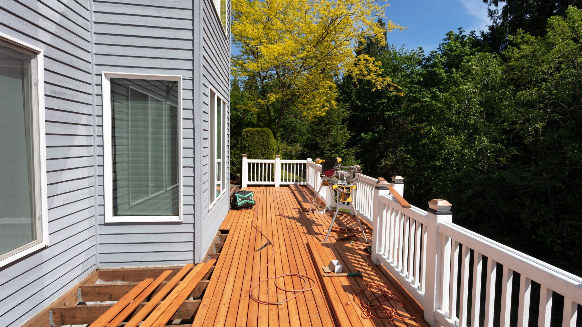 A wooden deck is being built on the side of a house