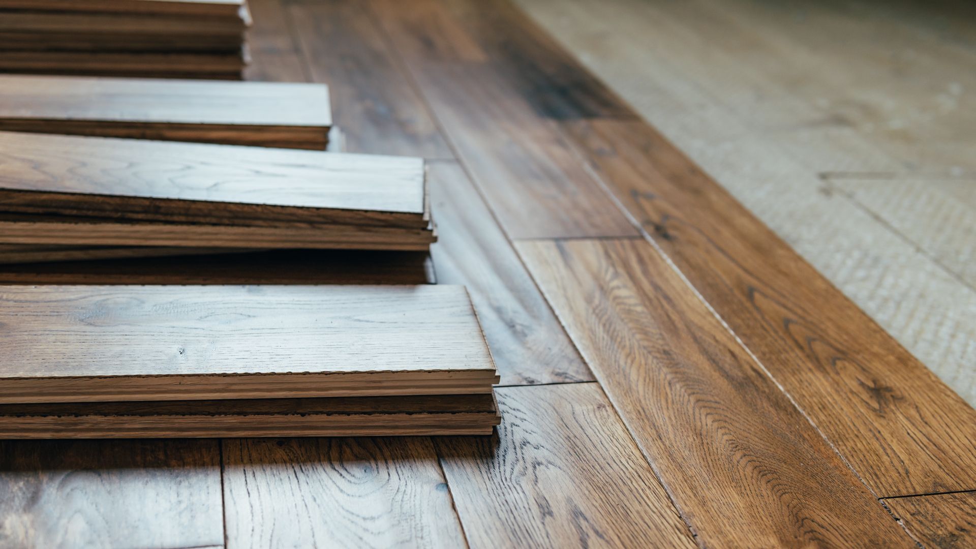 A stack of wooden planks sitting on top of a wooden floor.