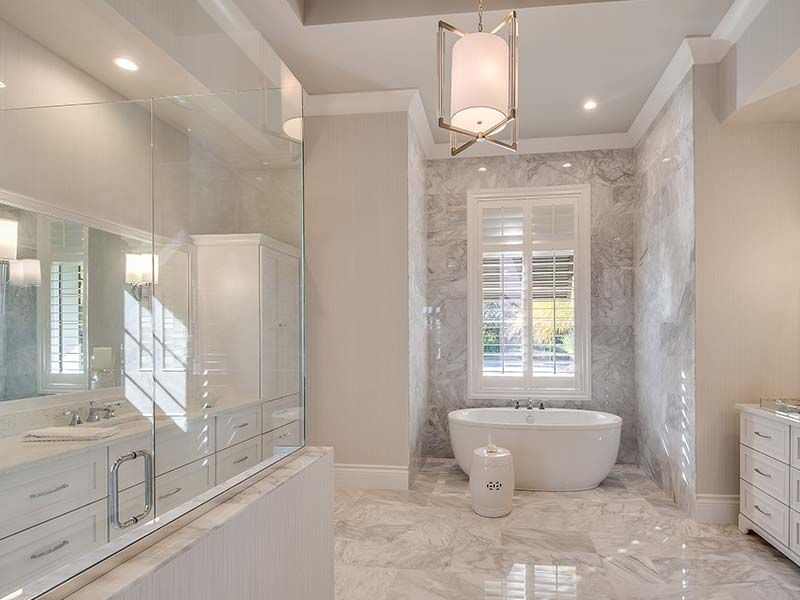 A bathroom with a tub , sink , mirror and walk in shower.