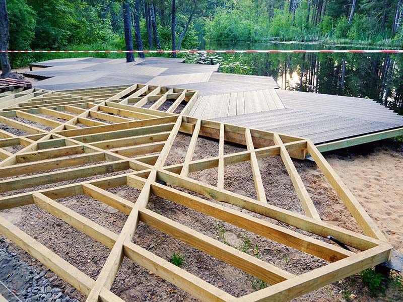 A wooden deck is being built in the middle of a forest.