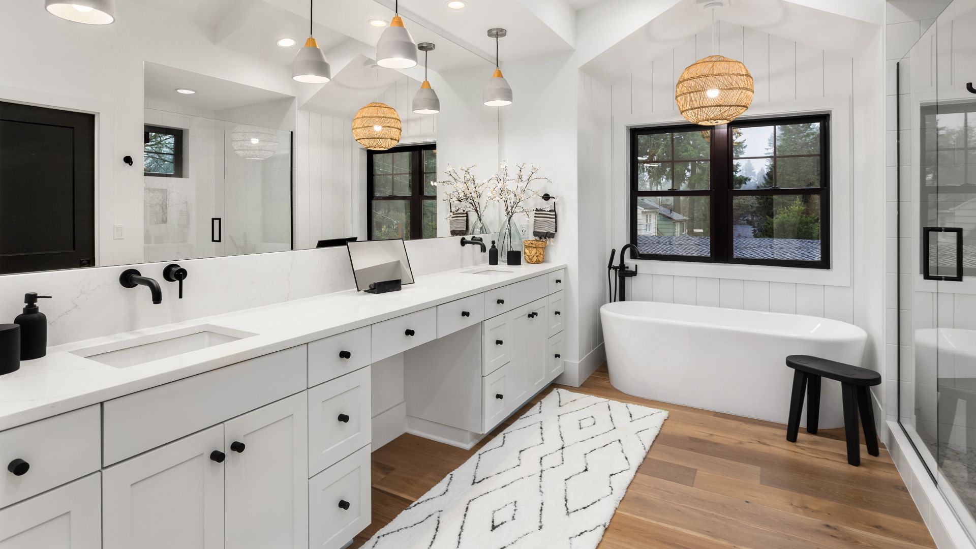 A bathroom with two sinks , a tub , and a shower.