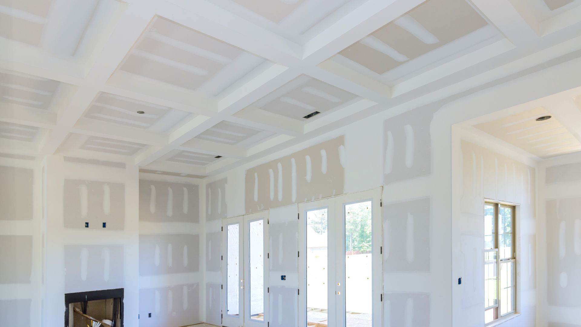 A living room with a fireplace and lots of windows under construction