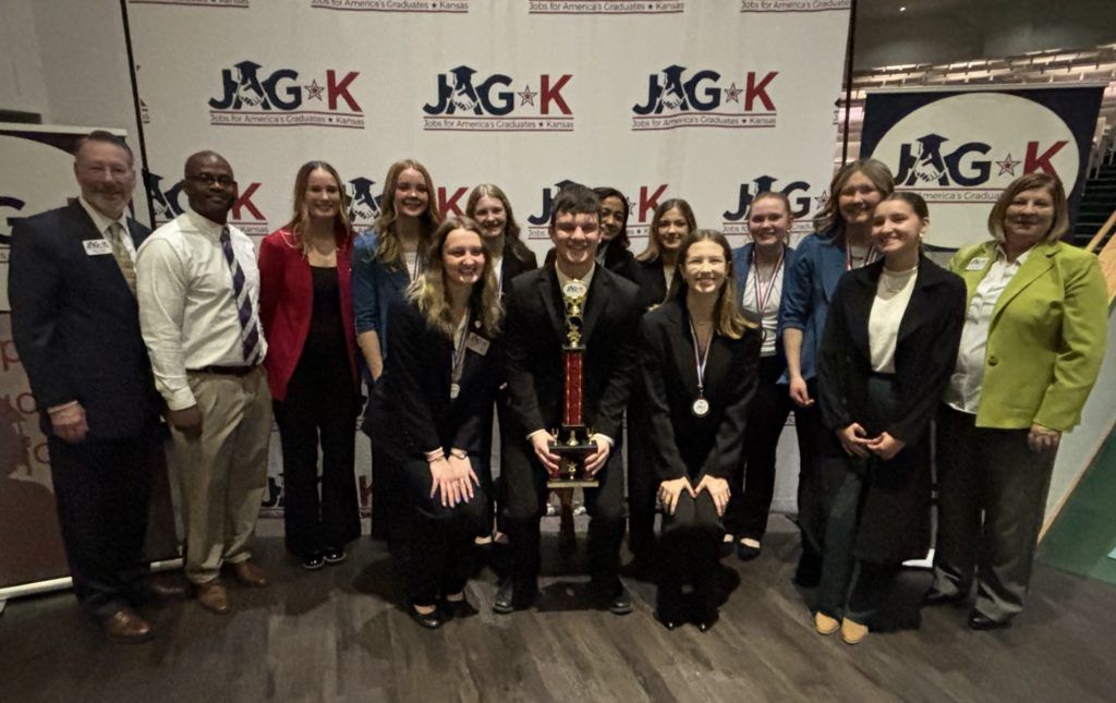 Group of people posing at an event in front of a branded M&G backdrop, dressed in formal attire.