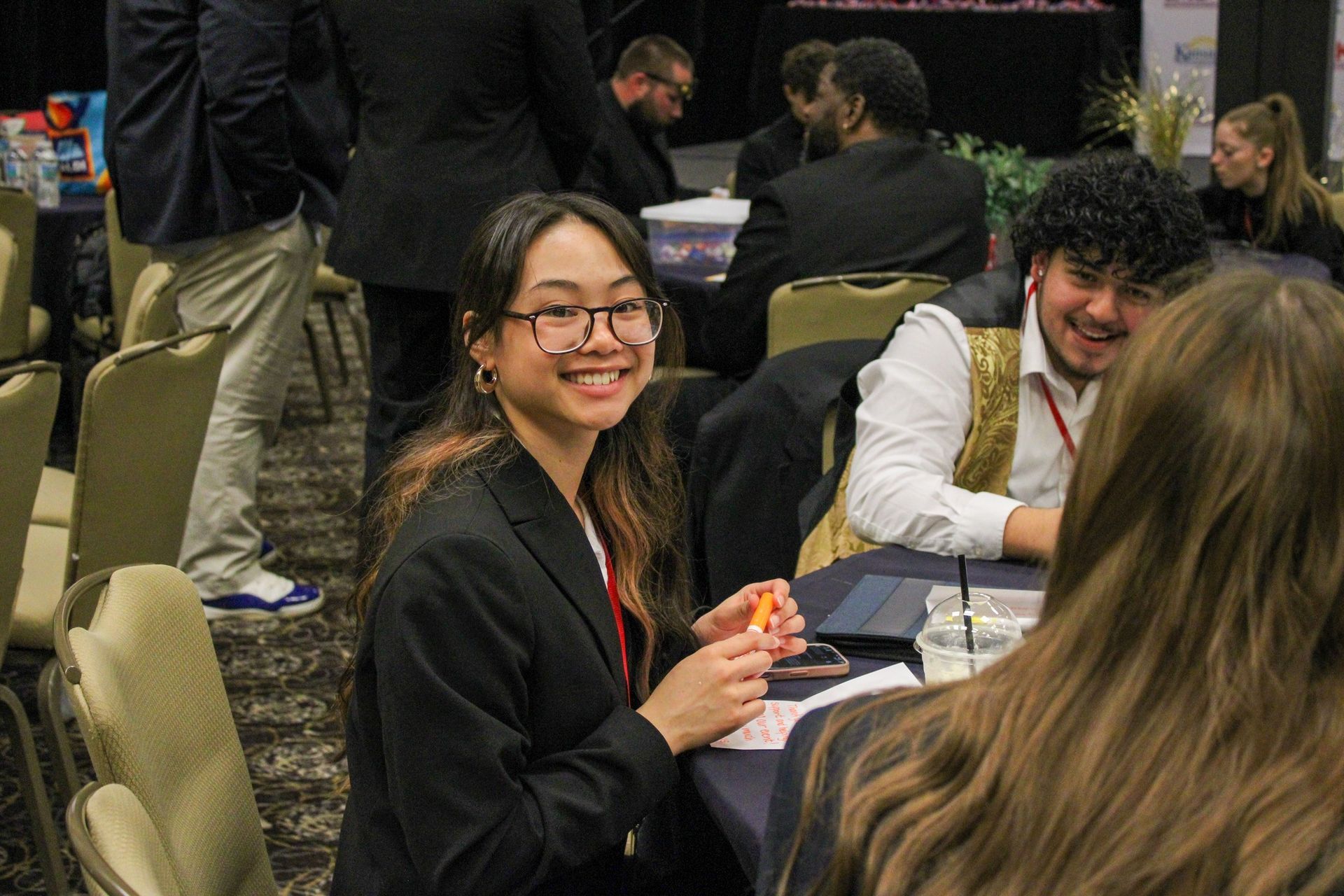 People seated at a conference table, smiling and talking during a group activity.
