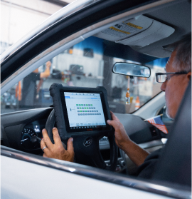 A person is using a tablet under the hood of a car | All-Star Automotive