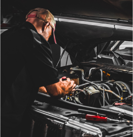 Two men working on a red car in a rotary liftv