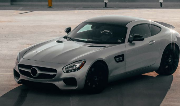 A silver sports car is parked in a parking lot.