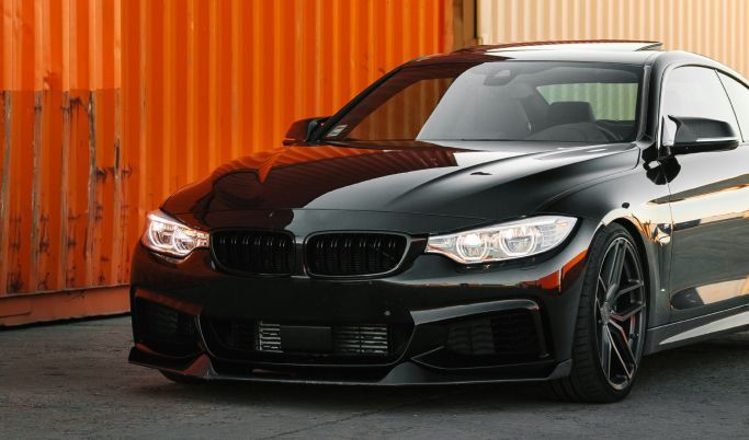 A black sports car is parked on the side of a road.