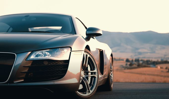 A black sports car is parked on the side of a road.