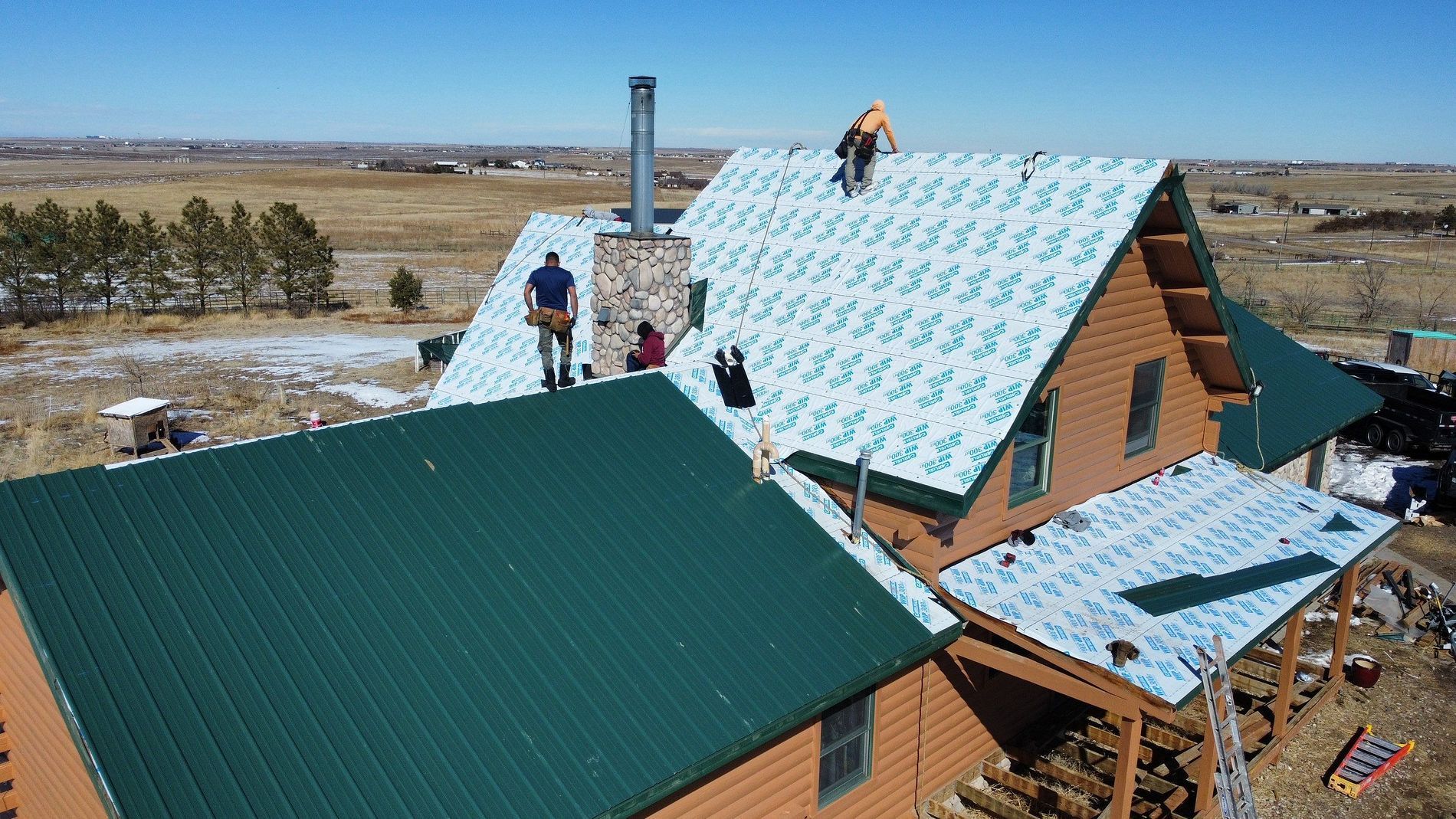 A group of people are working on the roof of a house.