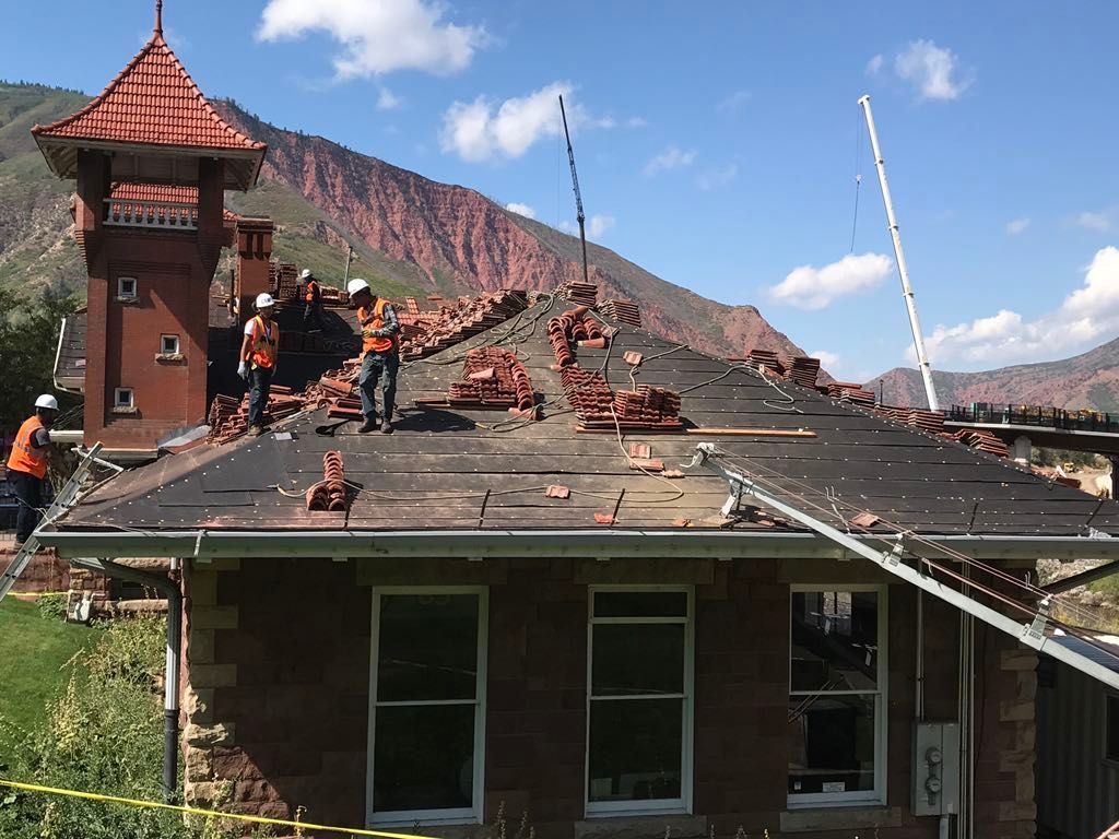 Commercial roofing contractor installing tile roof on a building.