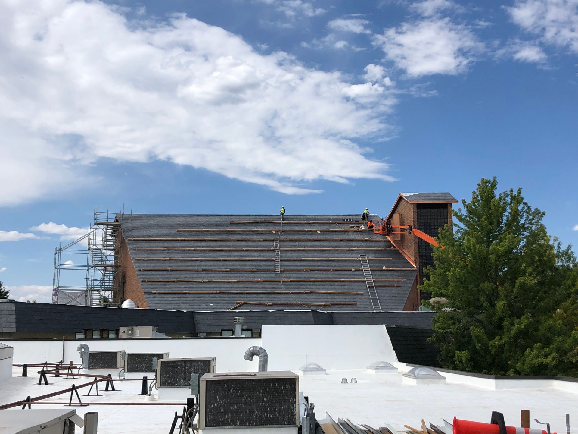 Roofing installation contractor crew installing new shingles.