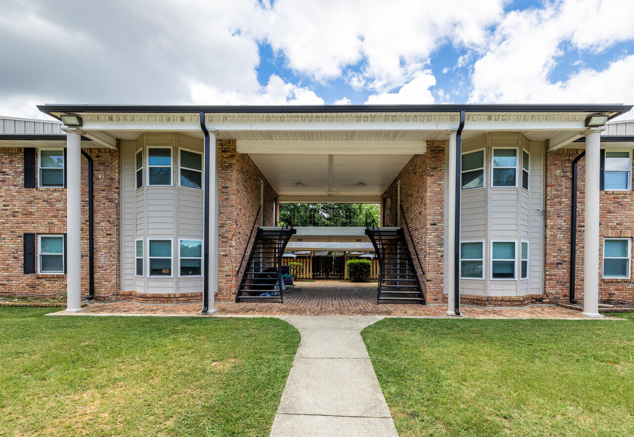 A large brick apartment building with stairs leading up to the second floor.