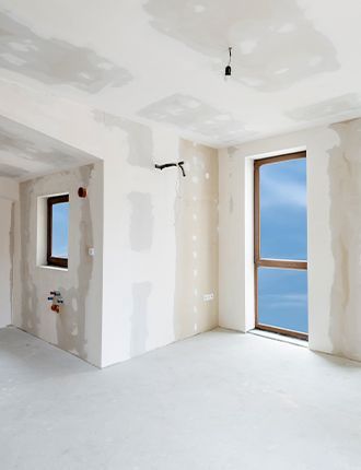 An empty room with drywall on the walls and a window.