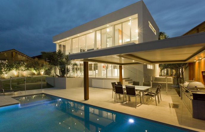 A house with a swimming pool and a table and chairs in front of it