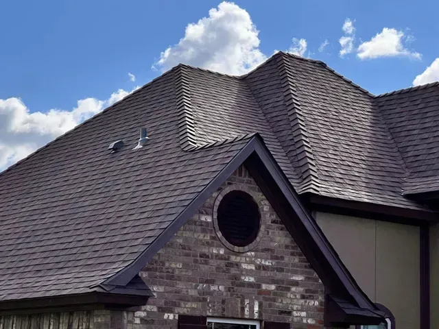 A large house with a brown roof and a brick facade.