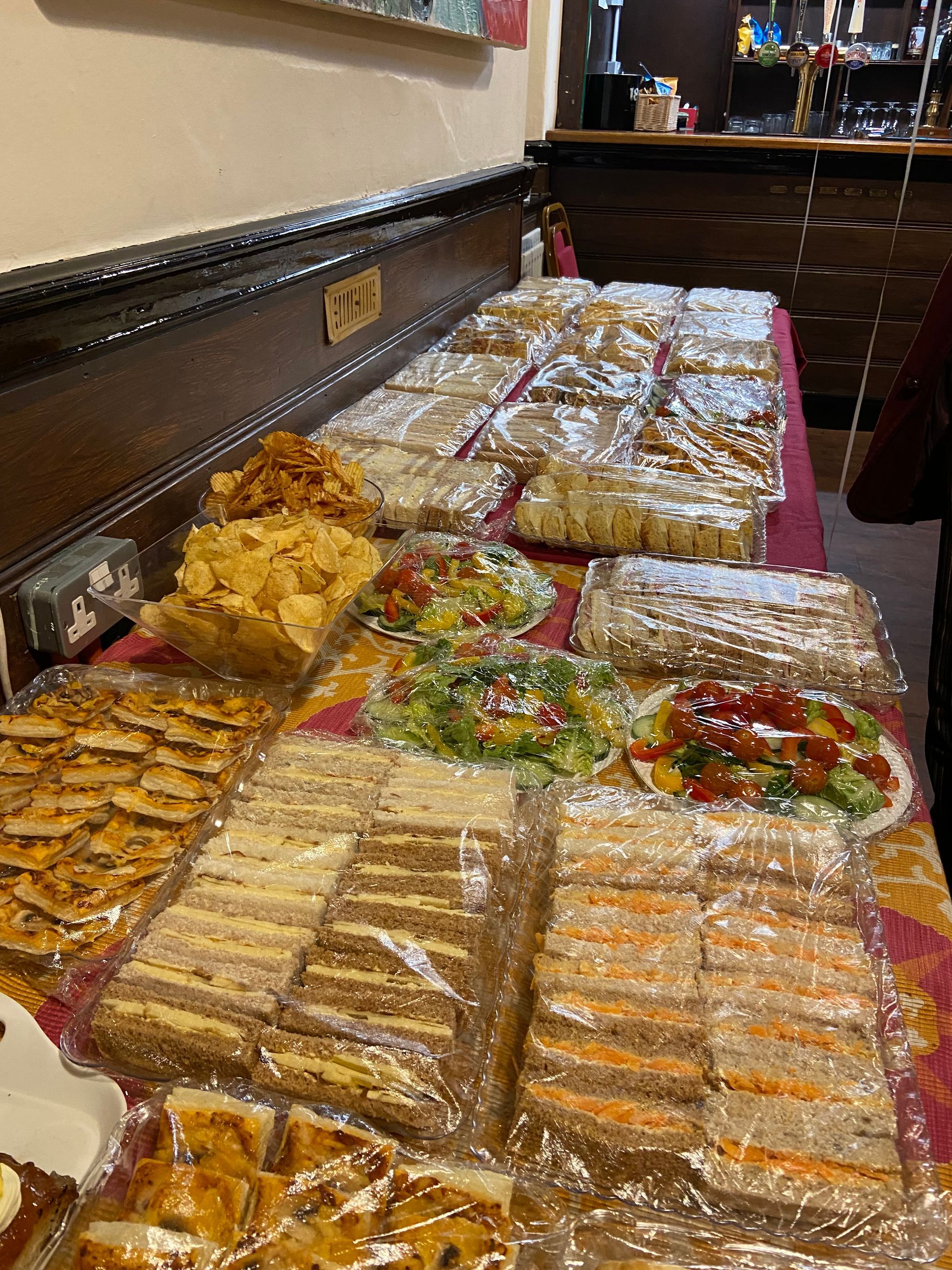 A table filled with lots of food including sandwiches and chips.