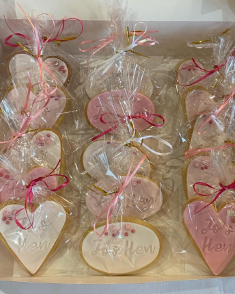 A box filled with heart shaped cookies wrapped in plastic.