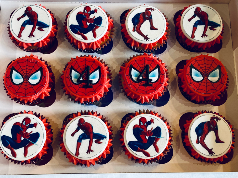 A box of spiderman cupcakes with spiderman faces on them