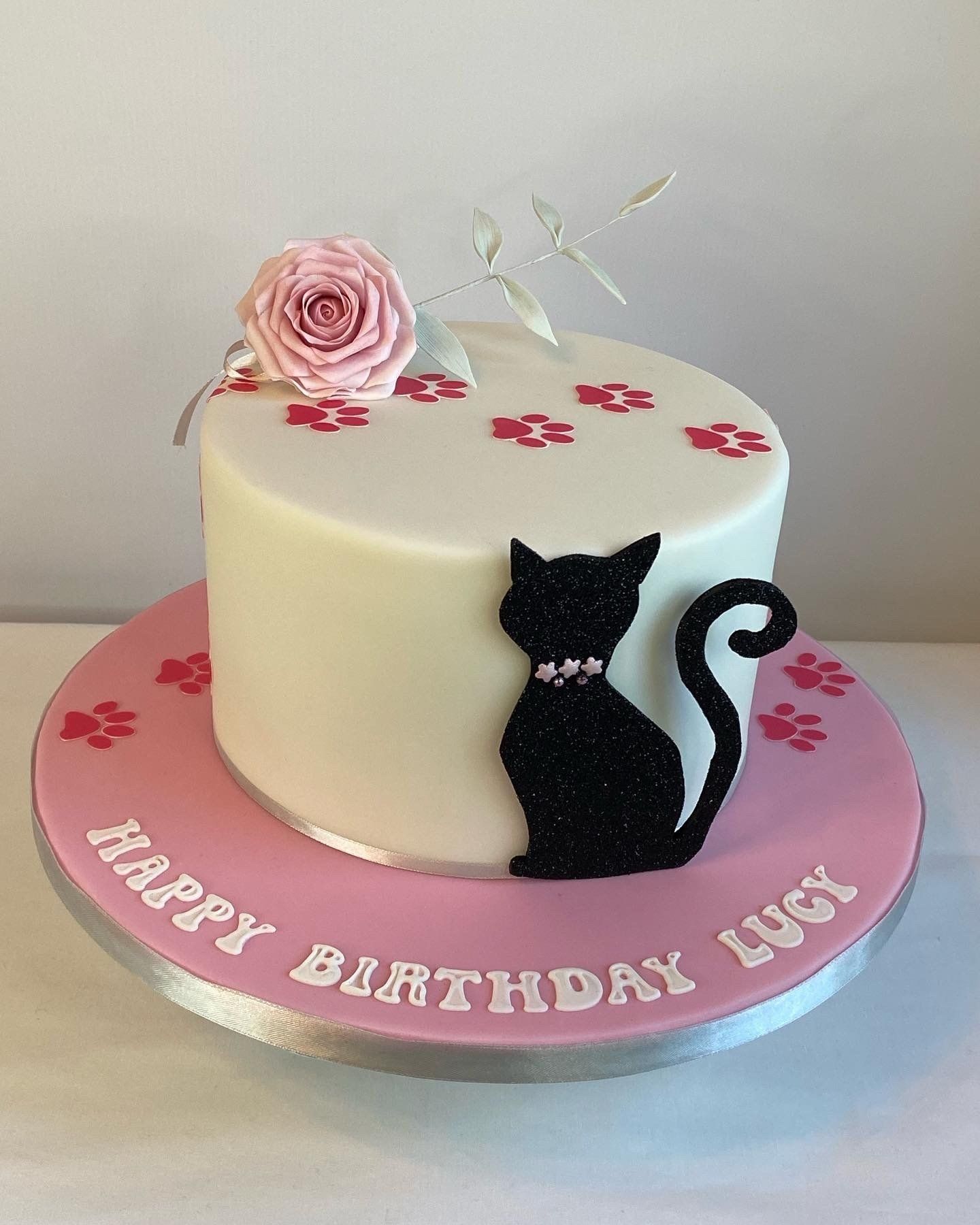 A birthday cake with a black cat on it