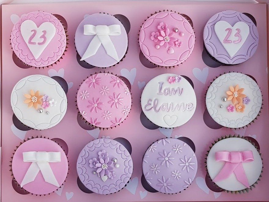A box of pink and purple cupcakes with the number 23 on them