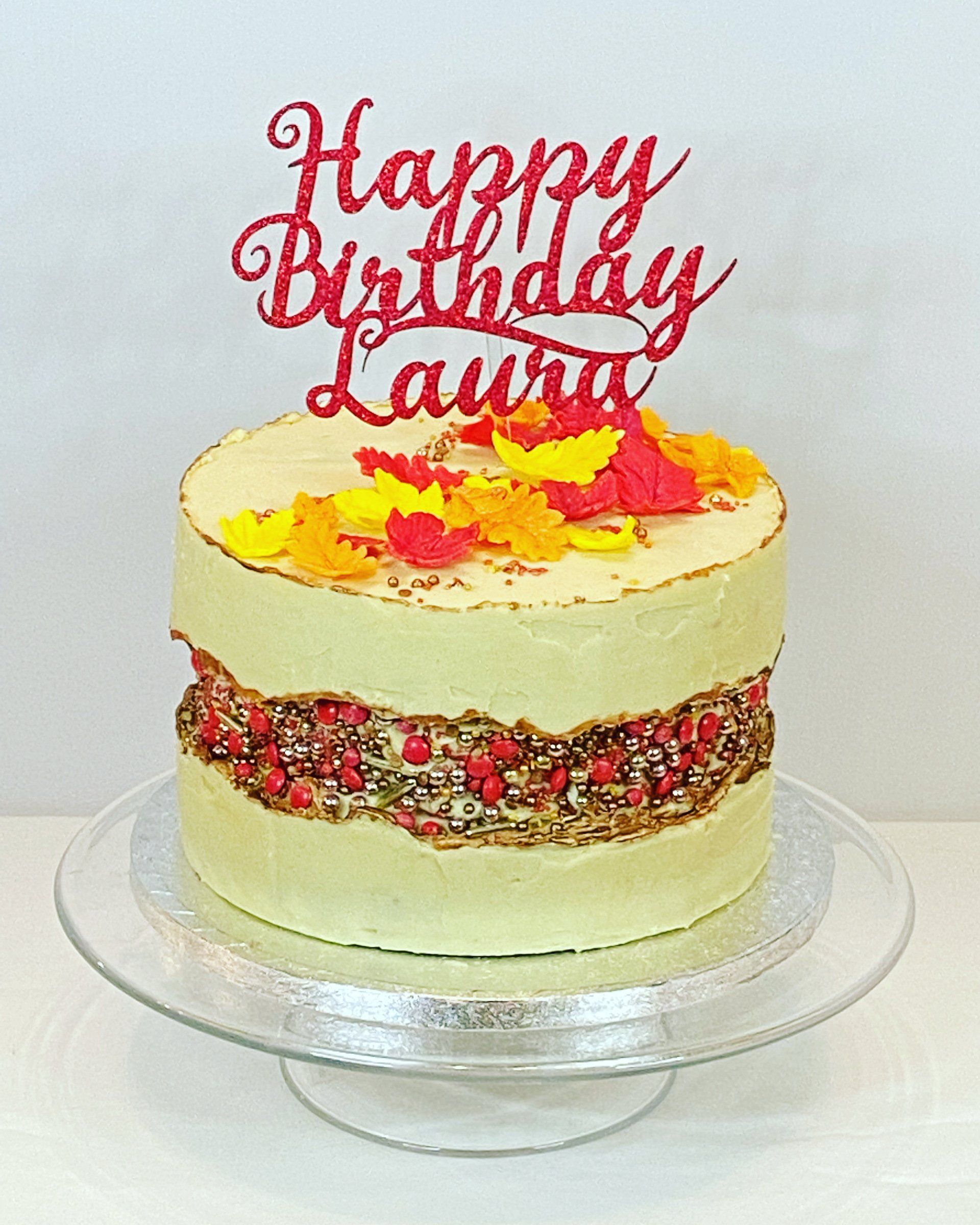 A birthday cake with a happy birthday laura cake topper