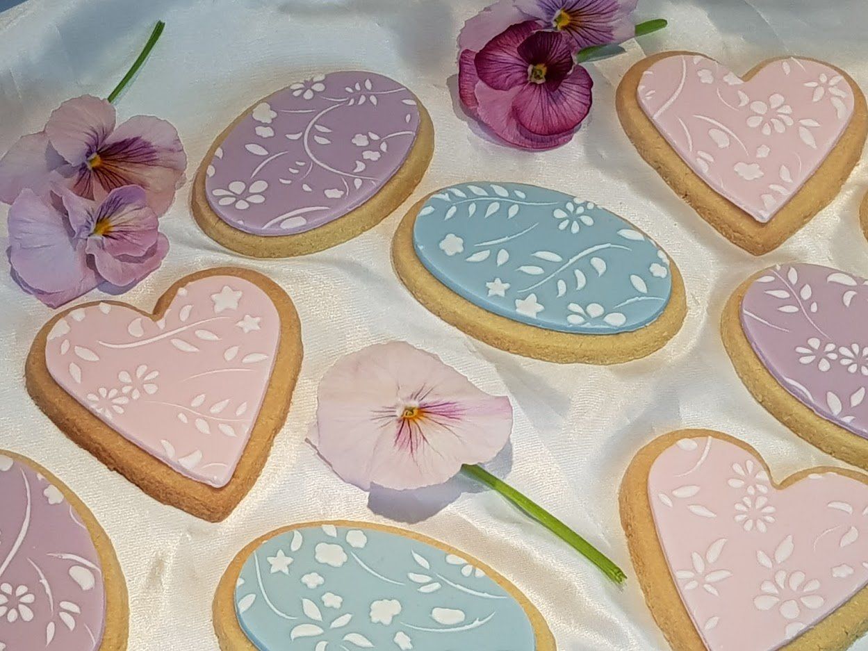 A bunch of heart shaped cookies with flowers on them