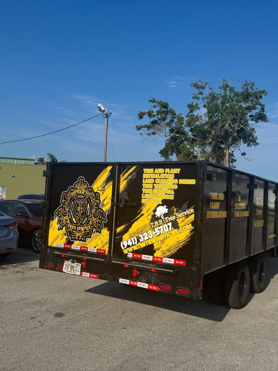 A black and yellow dump truck is parked in a parking lot.