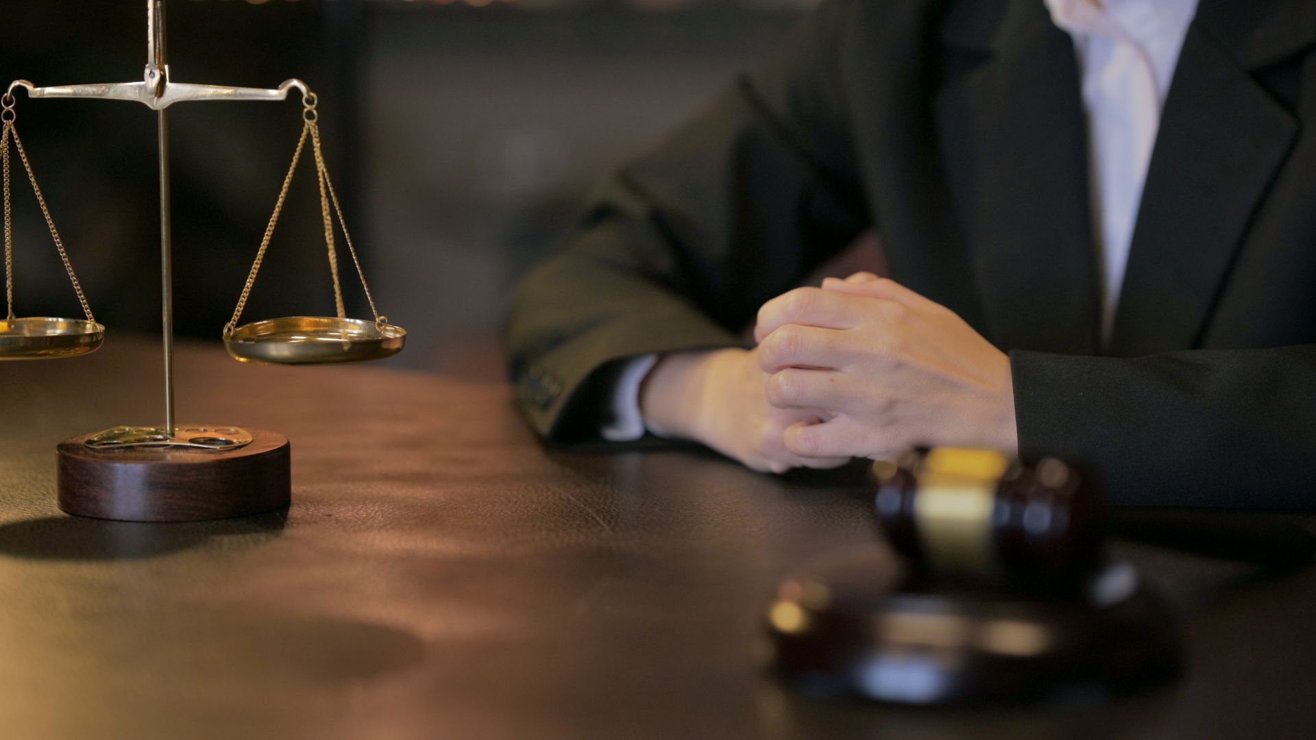 Auto accident attorney at desk with justice scales and gavel in legal office.