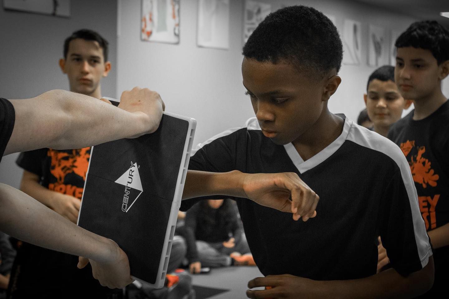 A group of young boys are practicing martial arts in a gym.