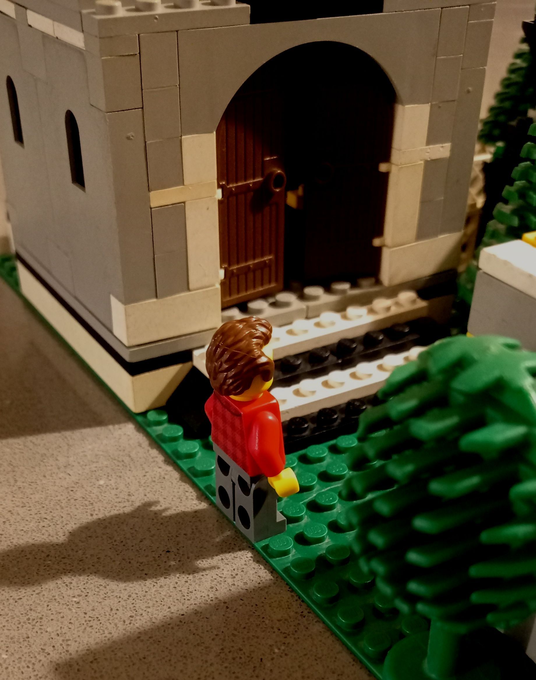 A lego figure is standing in front of a castle