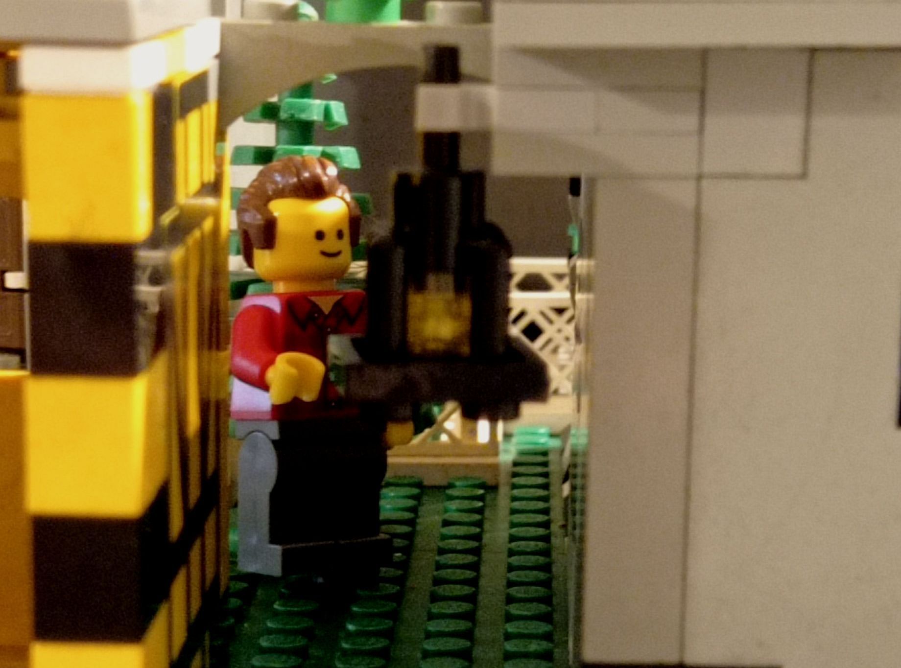 A lego figure is standing in a corner of a building