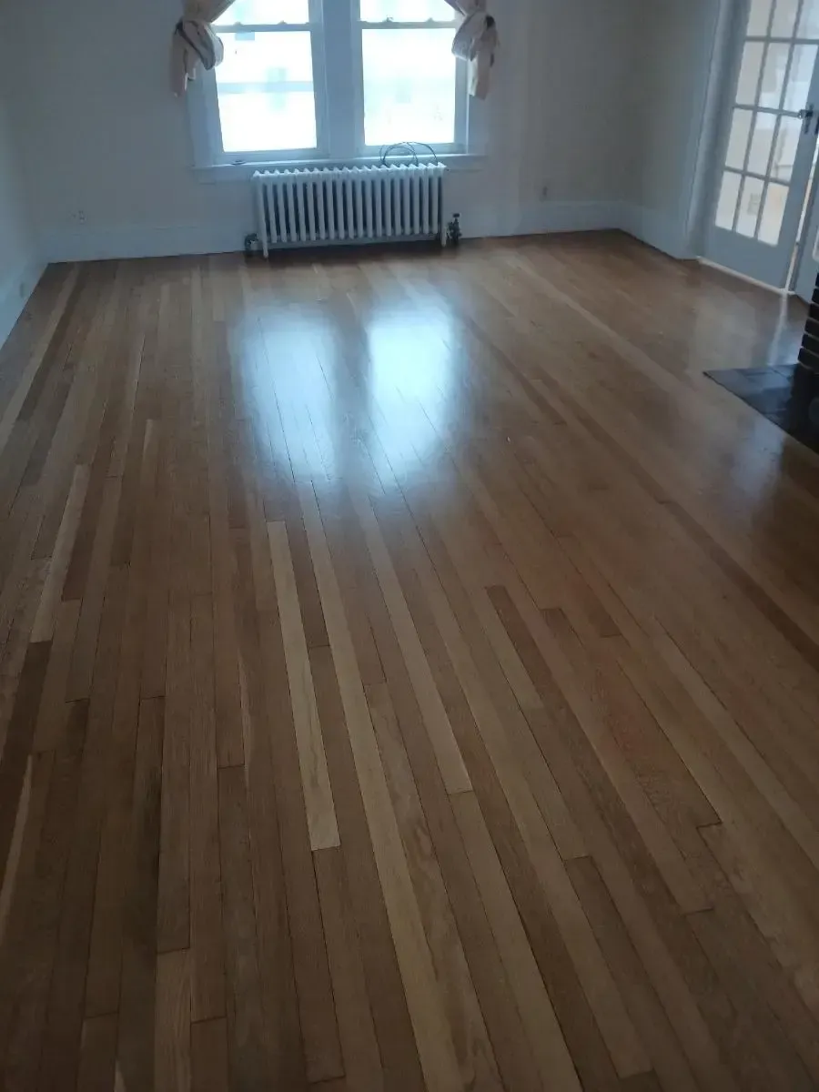Hardwood floor in an empty room, with light streaming through a window.